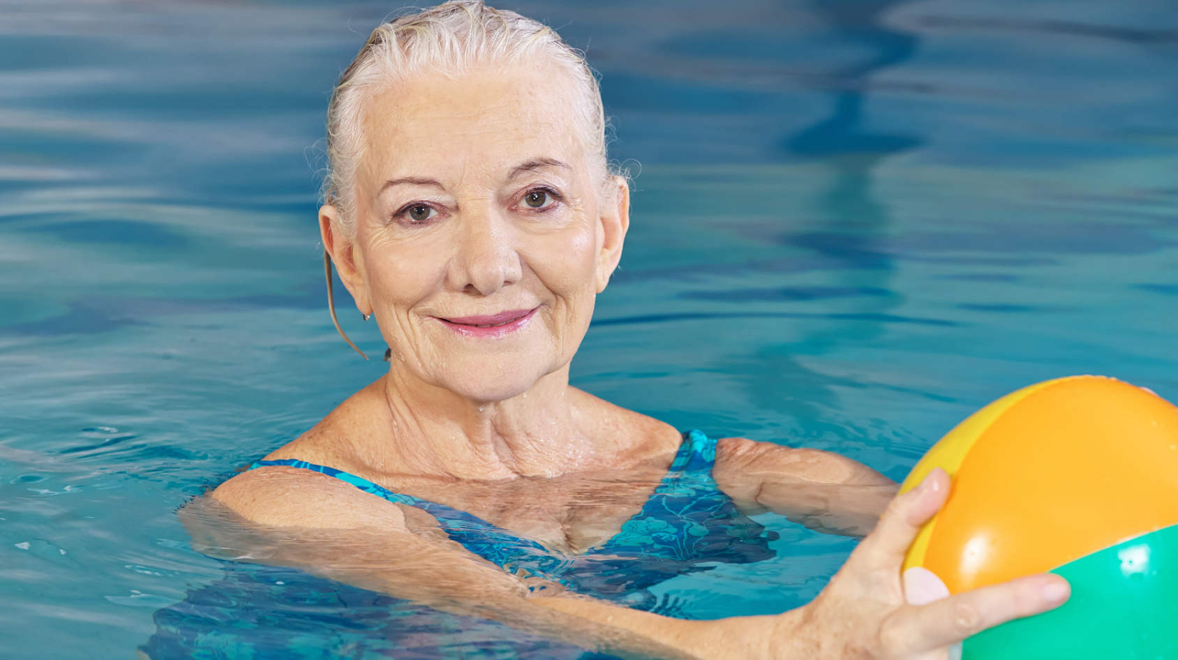 senior woman with water ball in pool (Fotolia.com)