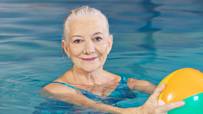 senior woman with water ball in pool (Fotolia.com)