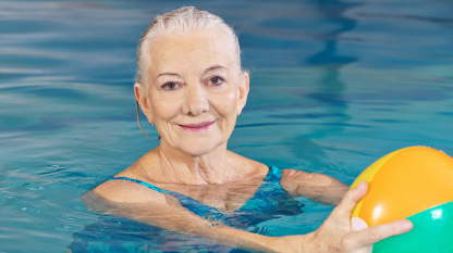 senior woman with water ball in pool